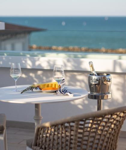 Tavolo con vista mare, due bicchieri di vino e un secchiello per il ghiaccio.