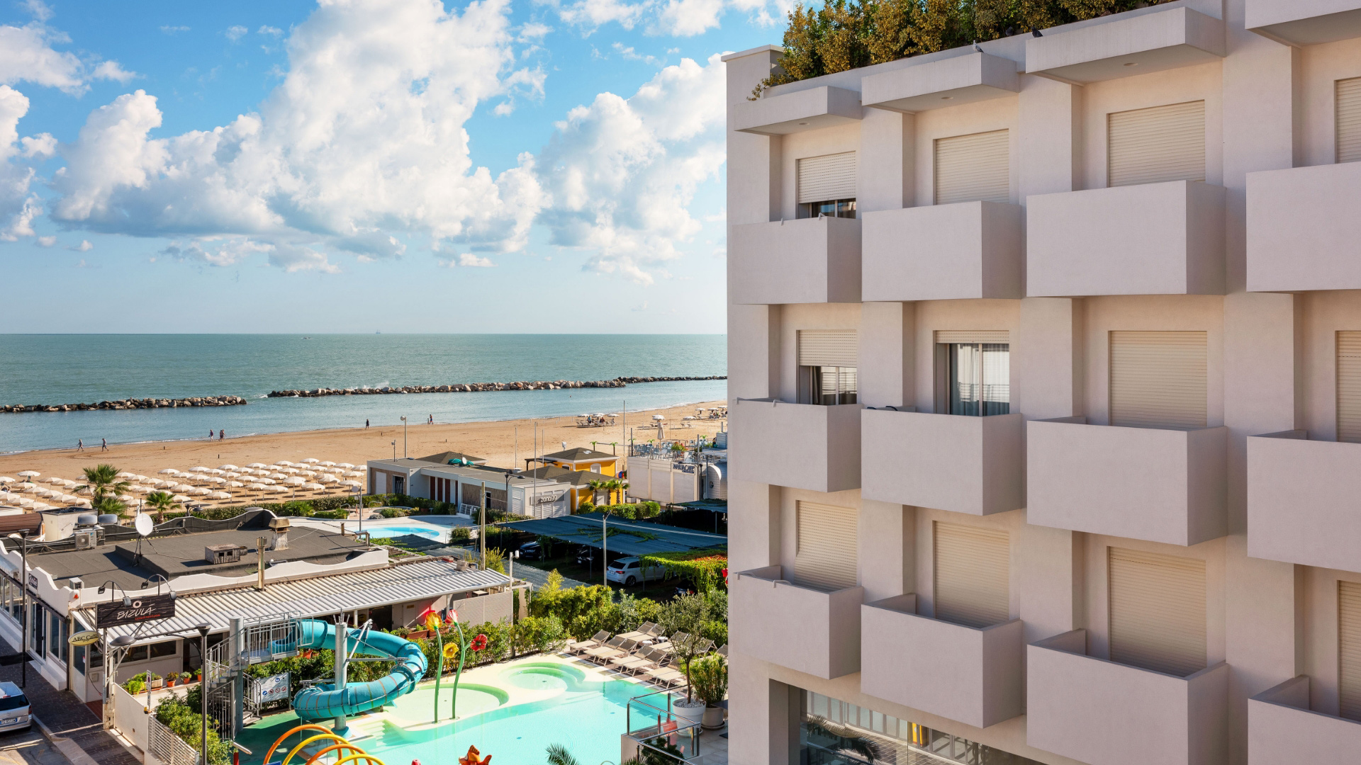 Vista sul mare con hotel moderno e spiaggia attrezzata.