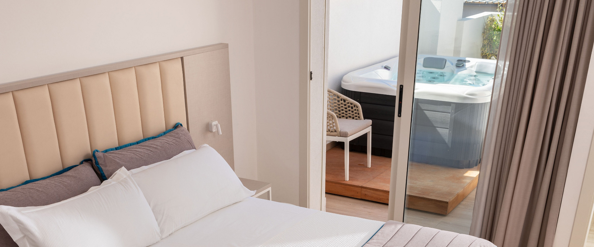 Camera da letto moderna con accesso a una terrazza con vasca idromassaggio.