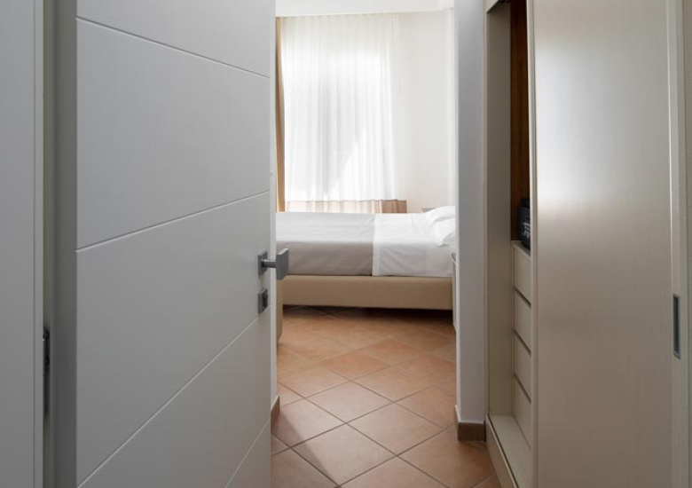 Ingresso di una camera da letto con pavimento in piastrelle e arredamento moderno.